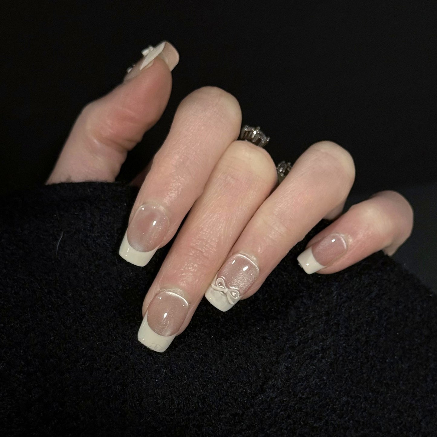 Ballerina Cat Eye Press-On Nails – Nude Base with French Tip and 3D White Bow Charms, Worn on Hand