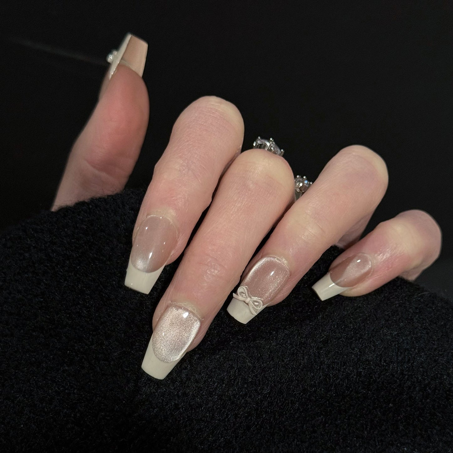 Ballerina French Tip Cat Eye Press-On Nails – Nude Base with 3D White Bow Charms, Worn on Hand