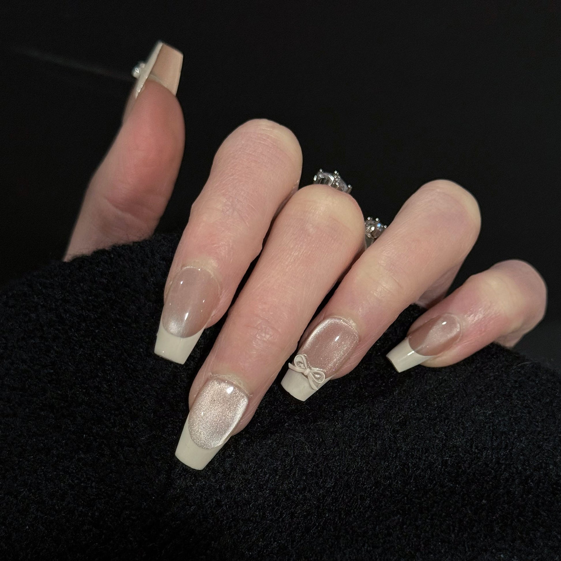 Ballerina French Tip Cat Eye Press-On Nails – Nude Base with 3D White Bow Charms, Worn on Hand