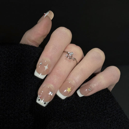 Peek a Boo French Tip Press-On Nails – Sheer Nude Base with Cat Face and Star Details, Worn on Hand
